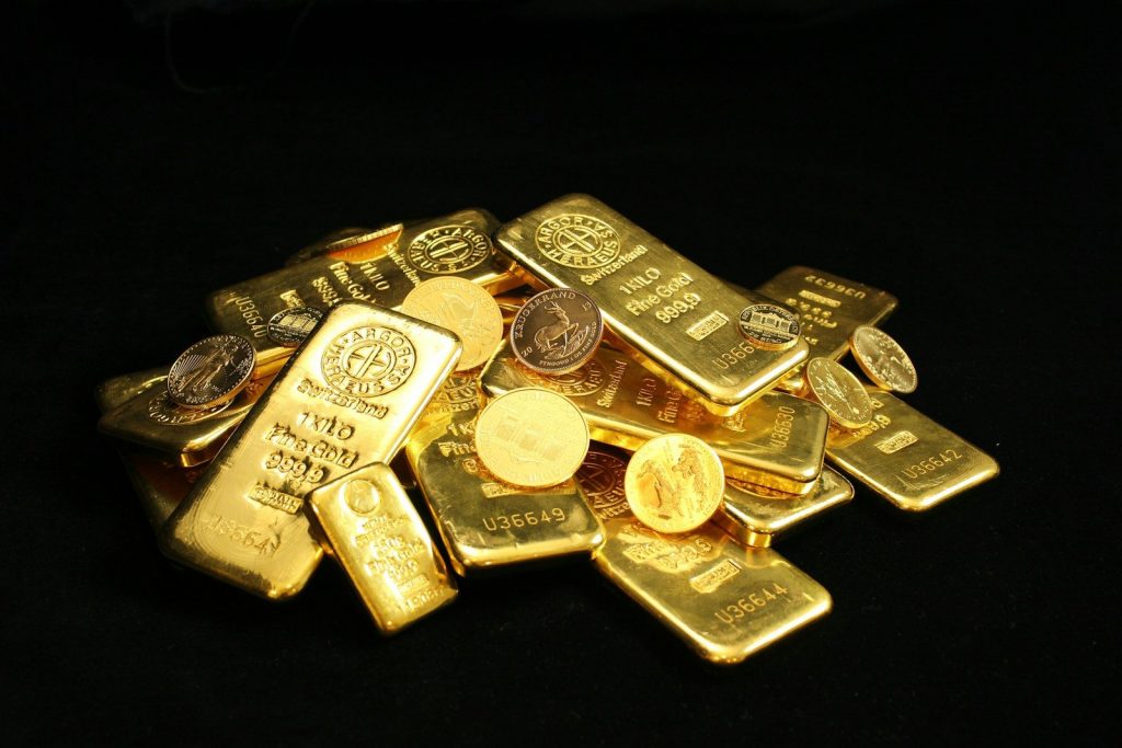 Gold bullion bars and investment-grade gold coins displayed on a black background, representing Gold IRA investing, gold IRA investment, TSP to gold IRA, gold IRA companies reviews, and converting IRA to physical gold for retirement portfolio diversification.